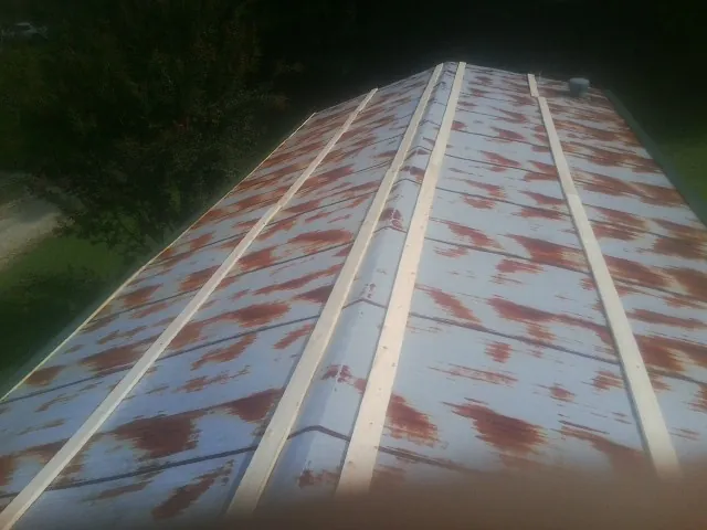 Rusted metal roof panels with new wood purlins before replacement — Storm Damage Roof Repair in Oldenburg by Roofing Brothers